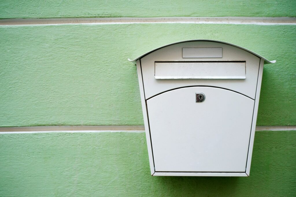 Postkasten vor grüner Wand