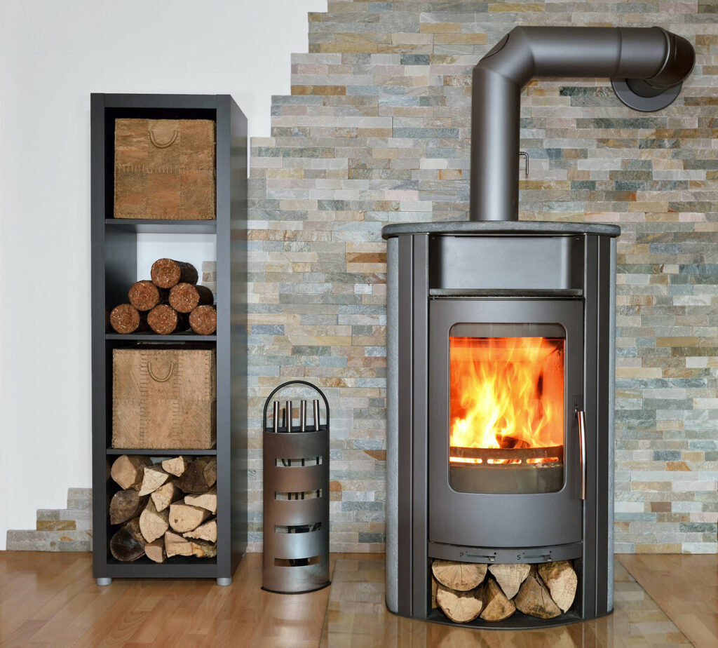 Kaminofen und Holzlager vor Wand